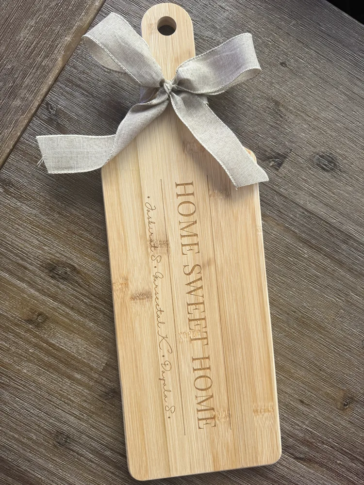 Bamboo paddle board engraved with Home Sweet Home, tied with a ribbon
