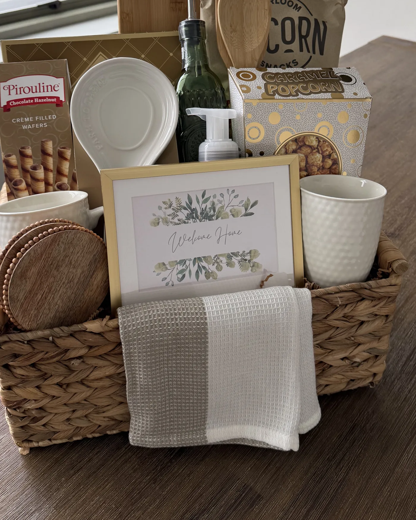 Welcome Home basket with charcuterie board, mugs and towel